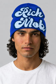 Bonnet Y2K 'Rich Mob' bleu — porté de face par notre modèle homme