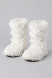 Bottes en moumoute blanches, paire seule sur fond studio gris clair.
