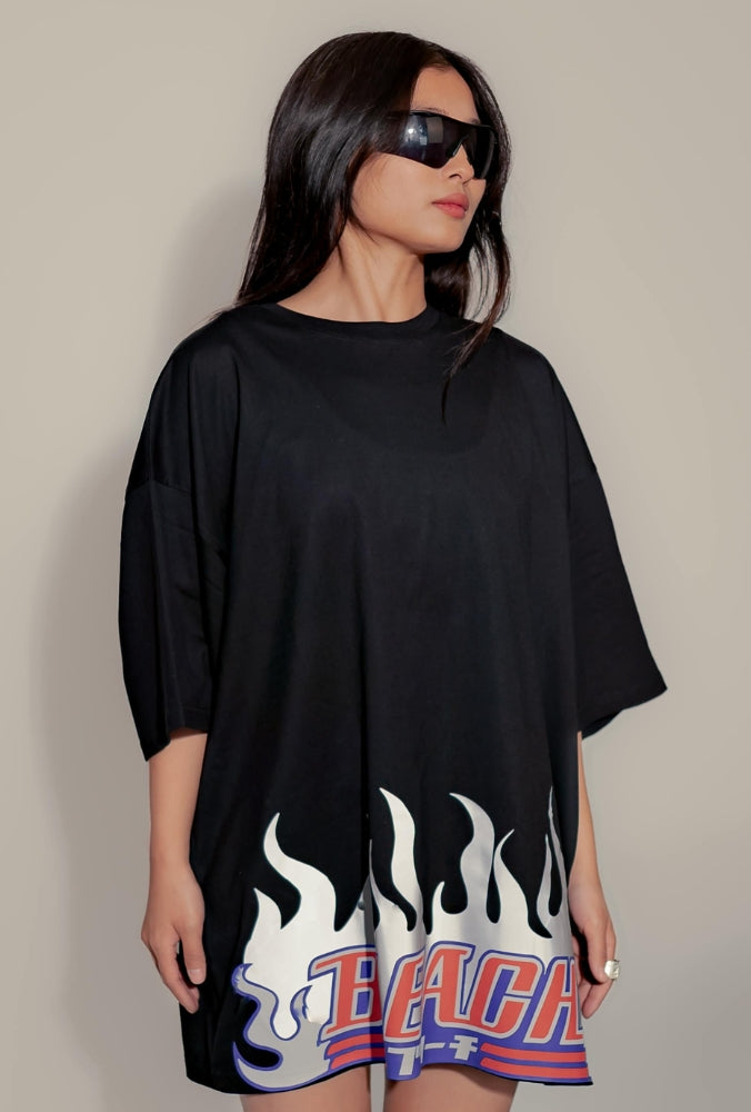 Femme portant un t-shirt oversize noire avec motif flammes et lunettes de soleil Y2K.