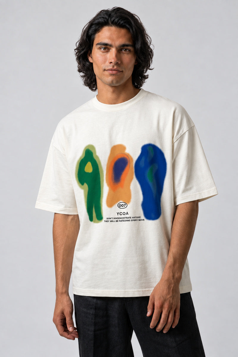 T-shirt écru oversize avec trois silhouettes graphiques verte, orange et bleue, porté de face.