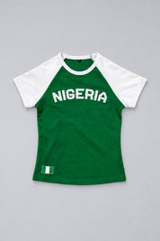 Baby tee Nigeria vert et blanc présenté à plat sur fond gris perle, avec lettrage Nigeria et drapeau.
