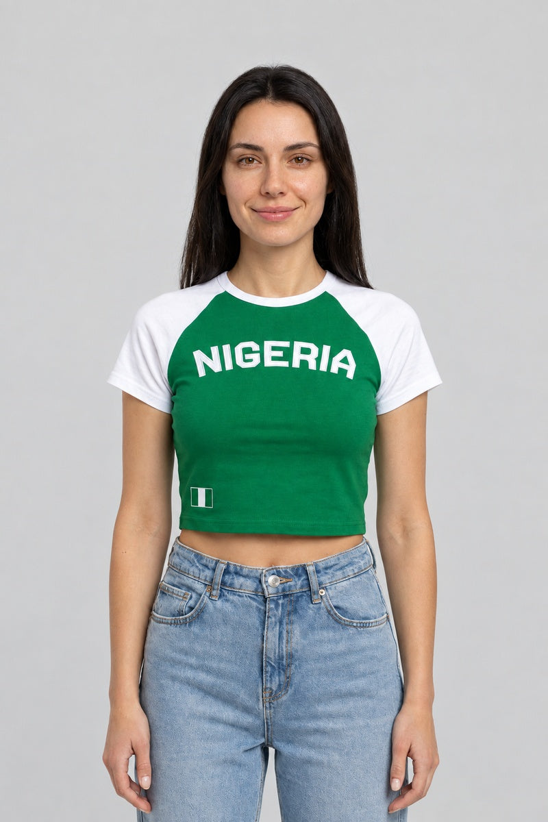 Baby tee Nigeria vert à manches raglan blanches, porté de face avec un jean bleu.