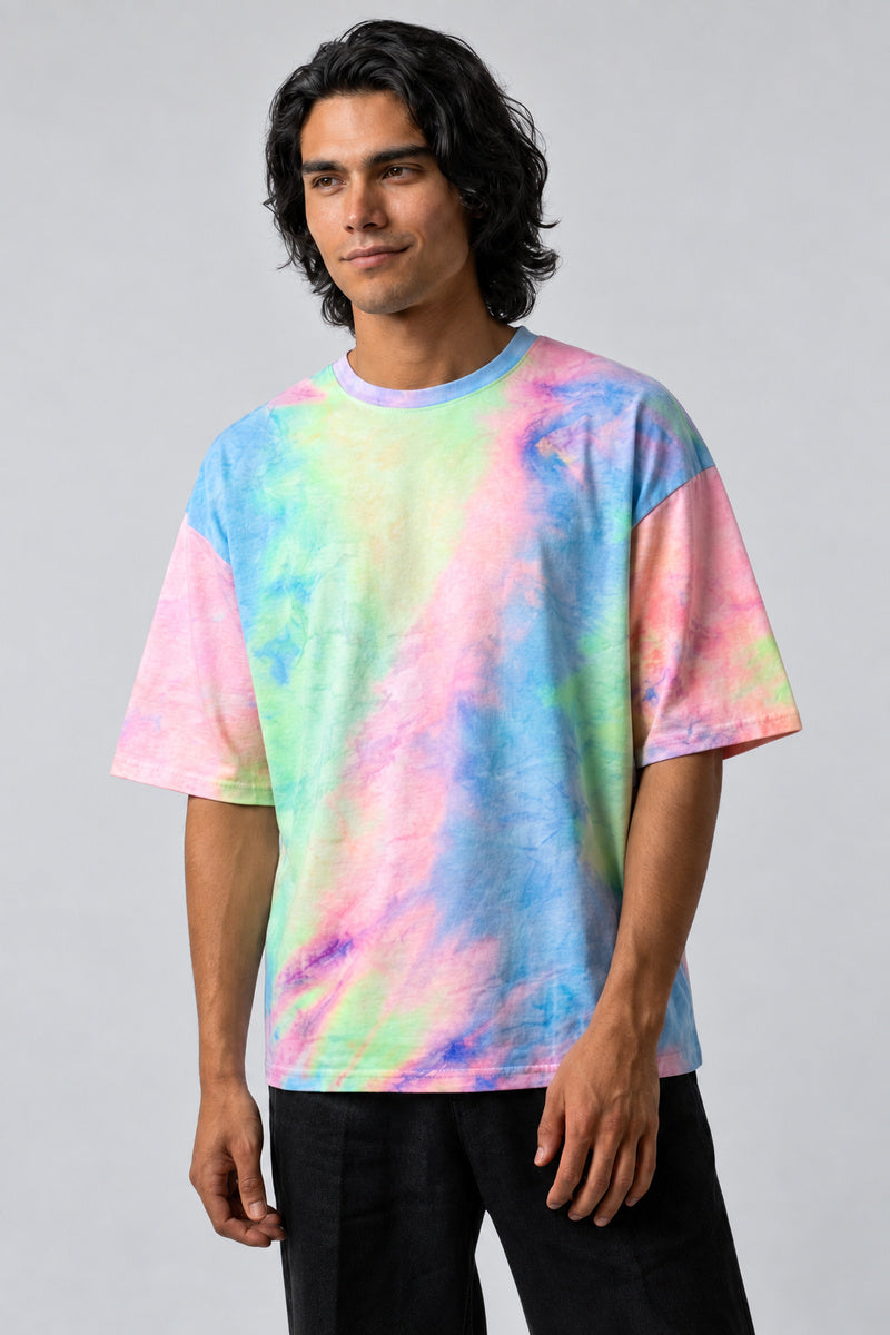 T-shirt oversize tie-dye pastel rose, bleu et vert, porté de face par un homme.